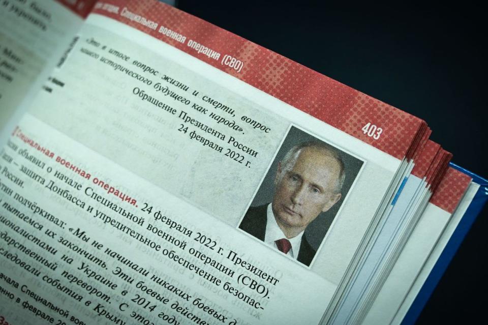 A portrait of Russian President Vladimir Putin is seen on a page of a new schoolbook for high school students on general world history and Russian history, mentioning the country's ongoing military action in Ukraine and the annexation of Crimea in 2014, during its presentation in Moscow on Aug. 7, 2023. (Yuri Kadobnov /AFP via Getty Images)