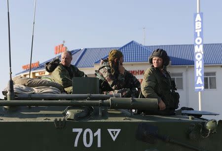 Russian military personnel sit atop an armoured vehicle outside Kamensk-Shakhtinsky, Rostov Region, August 15, 2014. REUTERS/Maxim Shemetov