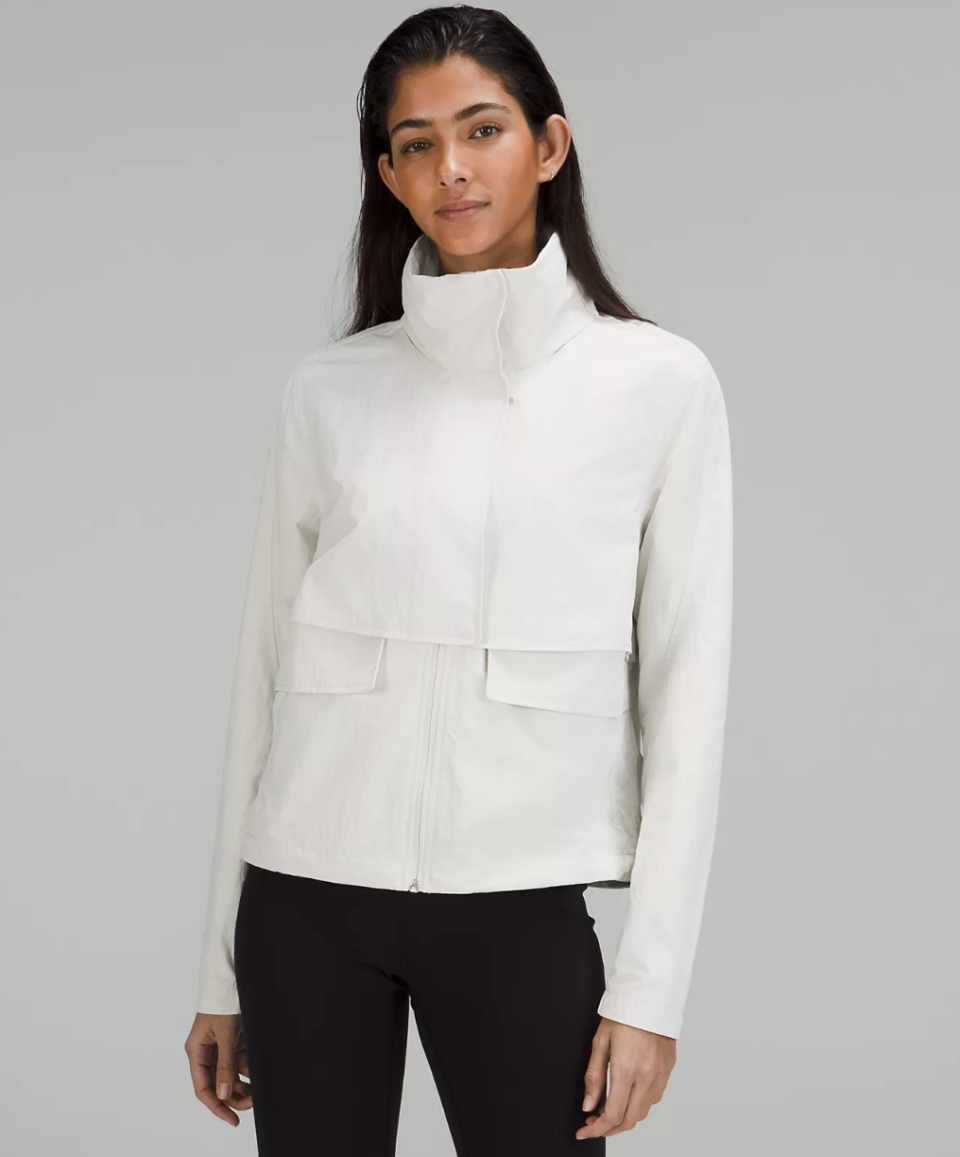 model wearing black leggings and white Always Effortless Jacket in bone (photo via Lululemon)