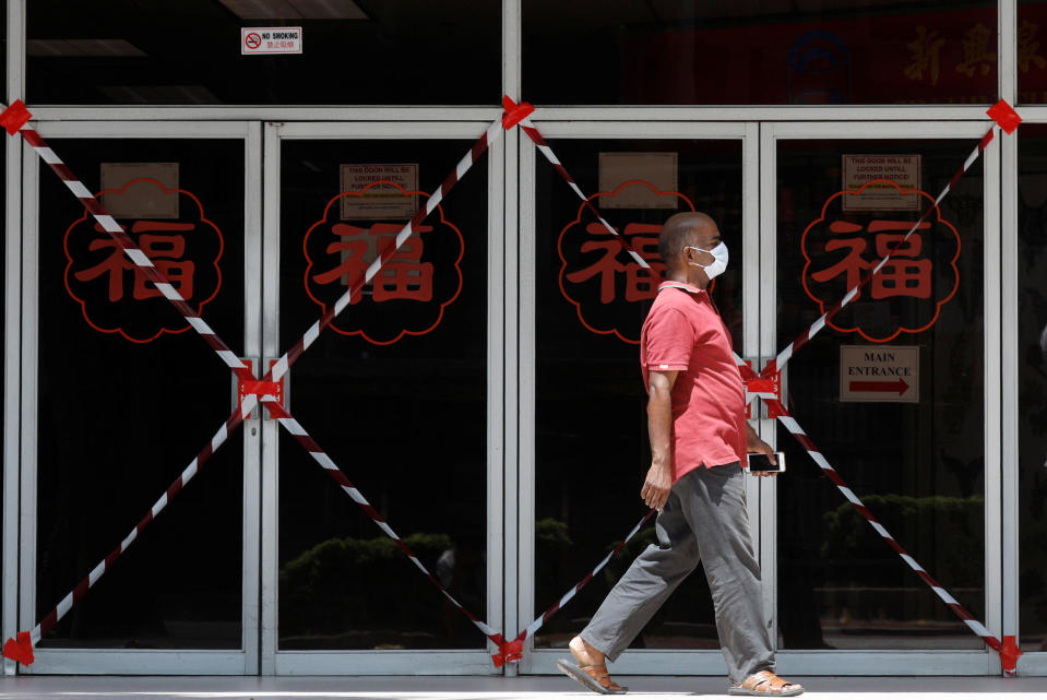 A man passes a closed-off mall amid the coronavirus outbreak here on 26 May, 2020. (PHOTO: Reuters)