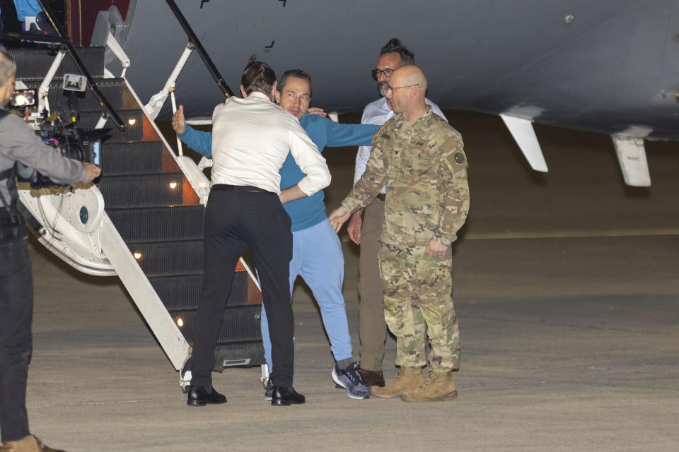 Freed American Eyvin Hernandez exits a State Department plane and is greeted by members of a Special Presidential Envoy for Hostage Affairs and Col. Mark Davis after he and nine fellow detainees were released in a prisoner swap deal between U.S. and Venezuela at Kelly Airfield Annex, Wednesday, Dec. 20, 2023, in San Antonio, Texas. Six of the Americans released arrived at Kelly Airfield Annex. | Stephen Spillman, Associated Press
