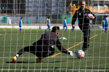Osama Abdul Mohsen, a Syrian refugee, warms up a goalkeeper before a soccer match with his junior team in Villaverde, a neighbourhood in Madrid, Spain, April 24, 2016. REUTERS/Sergio Perez