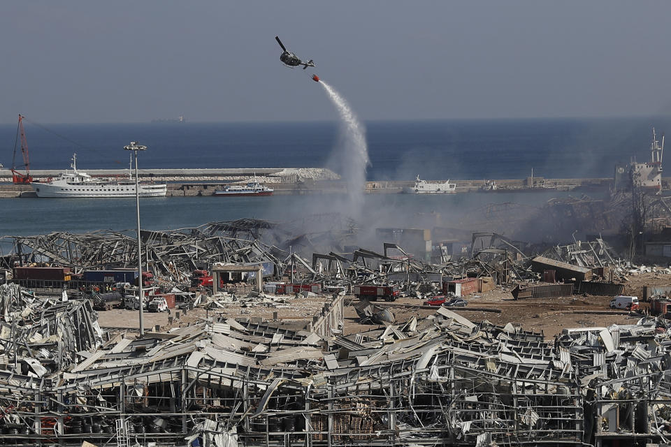 An army helicopter drops water at the scene of Tuesday's massive explosion that hit the seaport of Beirut, Lebanon, Wednesday, Aug. 5, 2020. (AP Photo/Hussein Malla)