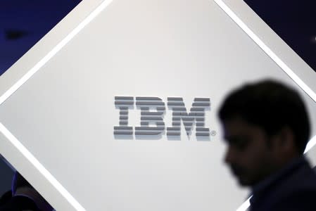 FILE PHOTO: Man stands near an IBM logo at the Mobile World Congress in Barcelona