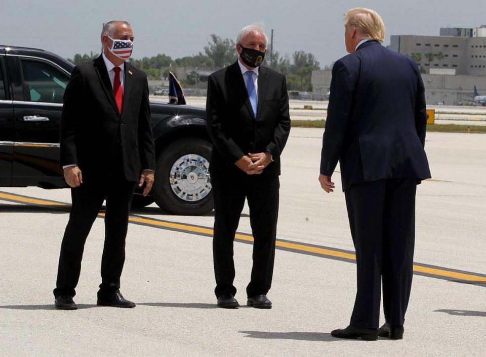 Miami-Dade County Mayor Carlos Gimenez, center, and County Commissioner Esteban Bovo welcome U.S. President Donald J. Trump as he arrives at Miami International Airport for a visit to the U.S. Southern Command and a meeting with the Venezuelan exile community in Doral on Friday, July 10, 2020.