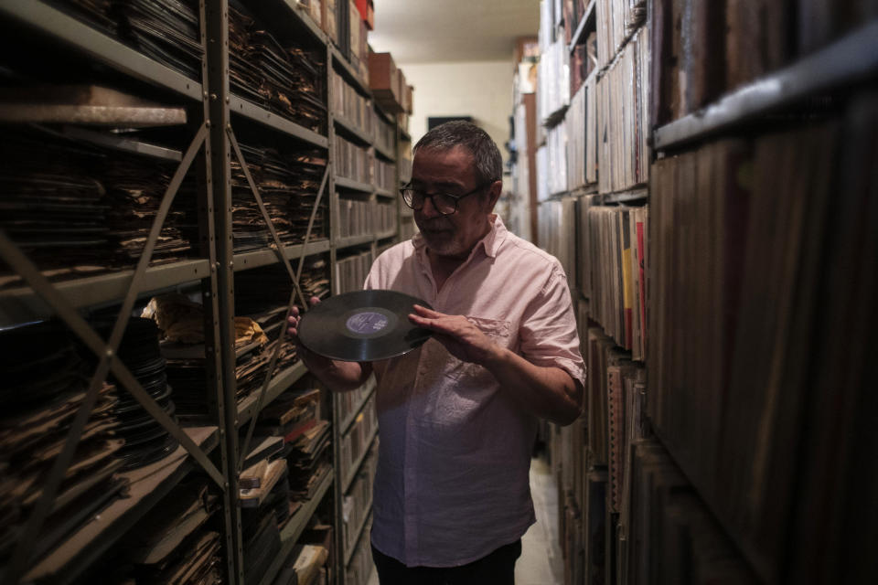 Carlos Savalla sostiene un álbum producido por la compañía discográfica brasileña RGE fundada en 1947, en su estudio donde mantiene su colección de música, en Río de Janeiro, Brasil, el viernes 19 de abril de 2024. Savalla, un productor musical de 66 años en Río, posee más de 60.000 discos de vinilo. (Foto AP/Bruna Prado)