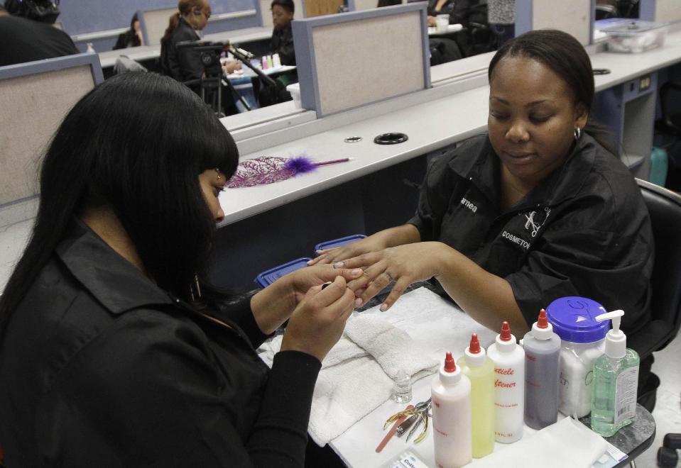 Shaqualana Tolefree, left, paints the nails of Jamea Daggs during class after a news conference at the Laney College School of Cosmetology in Oakland, Calif., Tuesday, April 10, 2012. Some nail polishes commonly found in California salons and advertised as free of a so-called “toxic trio” of chemicals actually have high levels of agents known to cause birth defects,according to state chemical regulators. (AP Photo/Jeff Chiu)