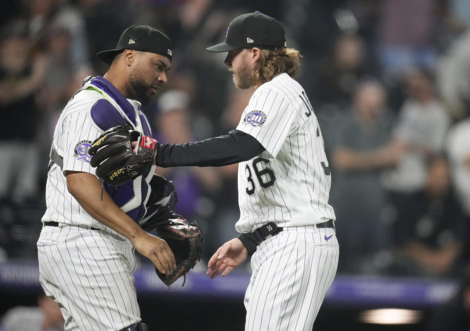 Colorado Rockies catcher Elias Diaz, left, congratulates relief pitcher Pierce Johnson after the team's win over the Miami Marlins in a baseball game Tuesday, May 23, 2023, in Denver. (AP Photo/David Zalubowski)