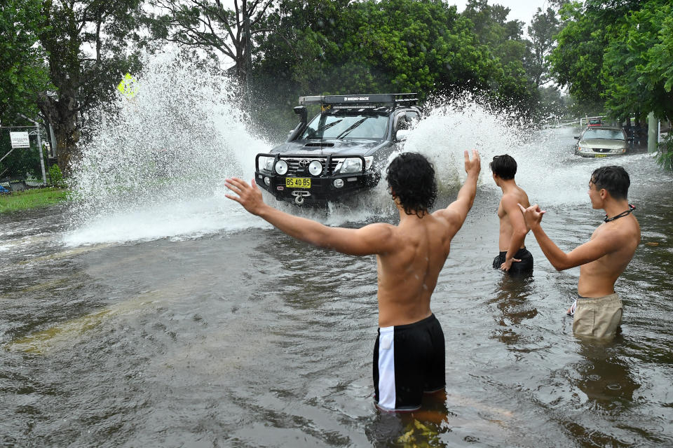 A group of boys direct traffic through floodwater at Tempe in Sydney, Sunday, February 9, 2020. Source: AAP