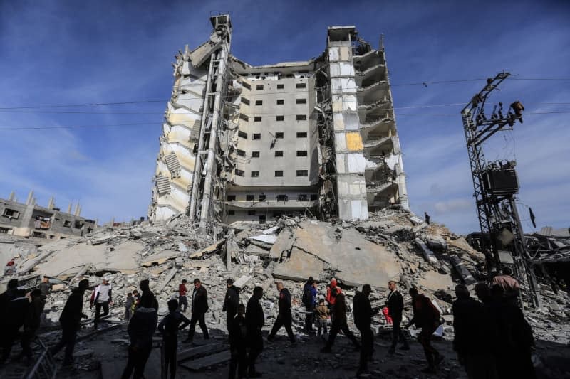 Palestinians inspect the massive damage caused by an Israeli air strike on Al-Masry Tower, downtown Rafah. Mohammed Talatene/dpa