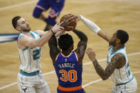 Charlotte Hornets forwards Gordon Hayward, left, and P.J. Washington, right, fight New York Knicks forward Julius Randle (30) for the ball in the first quarter of an NBA basketball game in Charlotte, N.C., Monday, Jan. 11, 2021. (AP Photo/Nell Redmond)