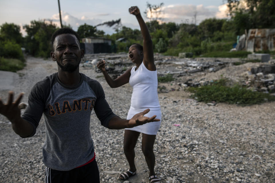 Felix Gelin and Claudine Jean describe in sign language how their community, the La Piste encampment, went up in flames this past summer, in Port-au-Prince, Haiti, Sunday, Sept. 20, 2021. According to residents and a United Nations account, police lead the assault at dusk on the encampment, a shelter for deaf and disabled Haitians relocated there by the International Red Cross after the 2010 earthquake leveled the capital. (AP Photo/Rodrigo Abd)