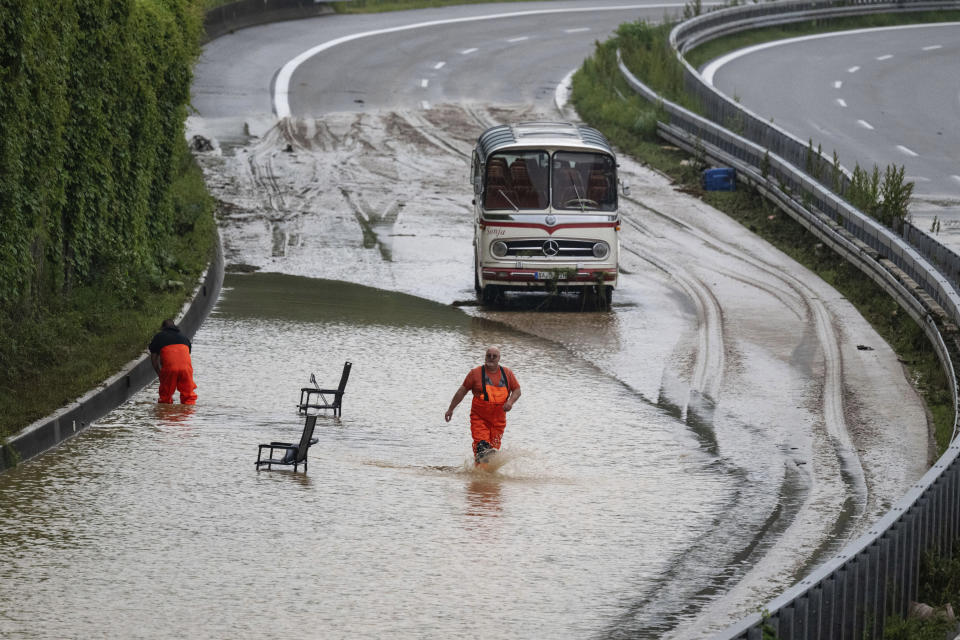 Emergency crews work on the flooded federal highway 10 near a burst noise barrier, in Ebersbach, Germany, Monday, June 3, 2024. Persistent heavy rain led to widespread flooding in the southern states of Bavaria and Baden-Wuerttemberg over the weekend. (Marijan Murat/dpa via AP)