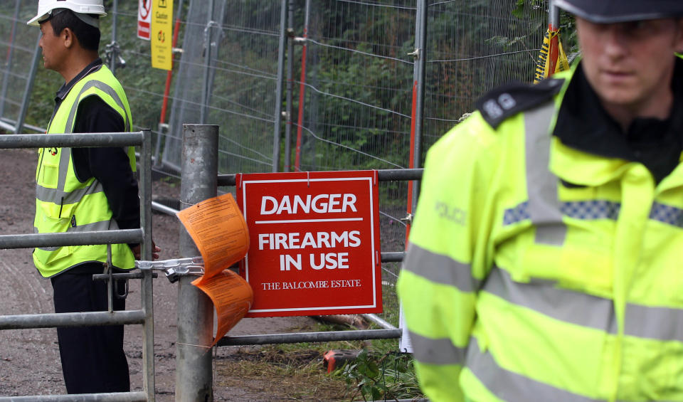 Police and security stand either side of a gate at the Balcombe fracking site in West Sussex as energy company Cuadrilla has started testing equipment ahead of exploratory oil drilling in the English countryside as anti-fracking protests at the site entered a ninth day.