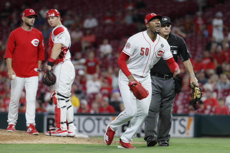 Cincinnati Reds relief pitcher Amir Garrett (50) charges the Pittsburgh Pirates dugout during the ninth inning of a baseball game,Tuesday, July 30, 2019, in Cincinnati. (AP Photo/John Minchillo)