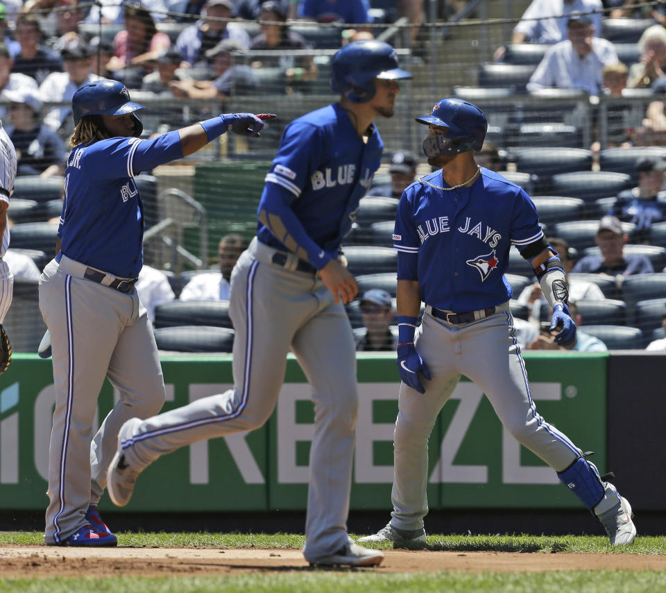 Toronto Blue Jays' Lourdes Gurriel Jr., right, celebrates his three-run home run with Cavan Biggio, center, and Vladimir Guerrero Jr. during the first inning of a baseball game against the New York Yankees at Yankee Stadium, Wednesday, June 26, 2019, in New York. (AP Photo/Seth Wenig)
