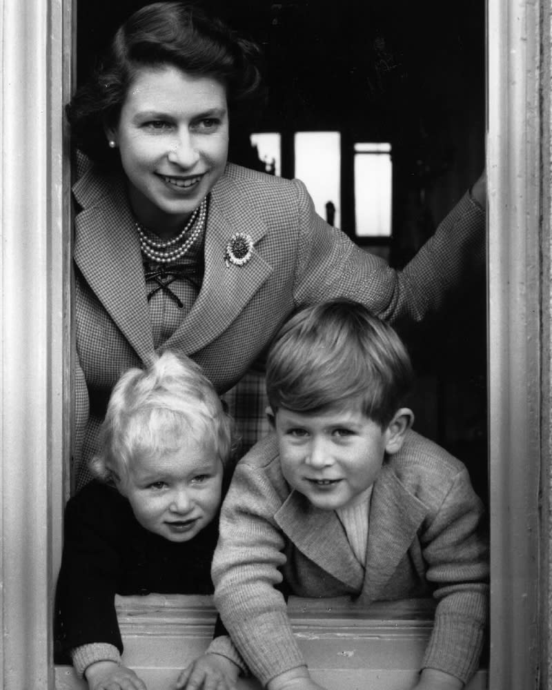 King Charles, Princess Anne and Queen Elizabeth II peek out of the window