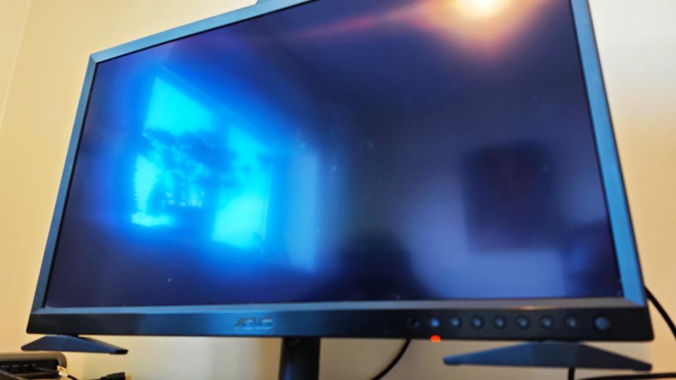 A black ASUS ProArt OLED PA32DC monitor sitting on a desk