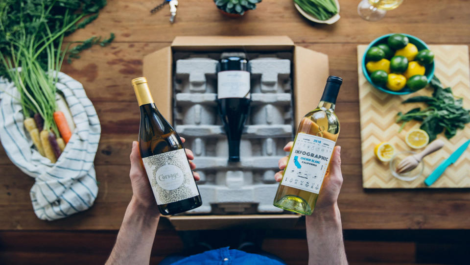 A pair of hands holding a wine bottle each above a box of Firstleaf wines.