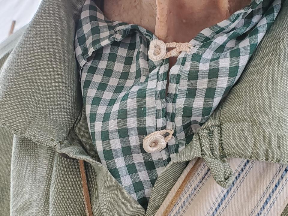 Uniform authenticity is important. Carroll White shows the thread buttons made by hand, by his wife June, seen during the American Independence Festival in Exeter Saturday, June 16, 2022.