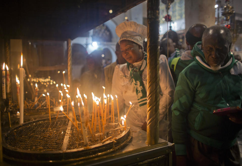 Christian worshippers light candles at the Church of the Nativity, traditionally recognized by Christians to be the birthplace of Jesus Christ, in the West Bank city of Bethlehem, Sunday, Dec. 23, 2018. Christians around the world will celebrate Christmas on Monday. (AP Photo/Nasser Nasser)