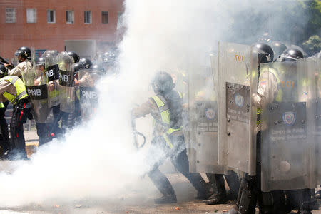 Policemen are seen amidst tear gas during clashes with demonstrators at an opposition rally in Caracas, Venezuela. REUTERS/Carlos Garcia Rawlins