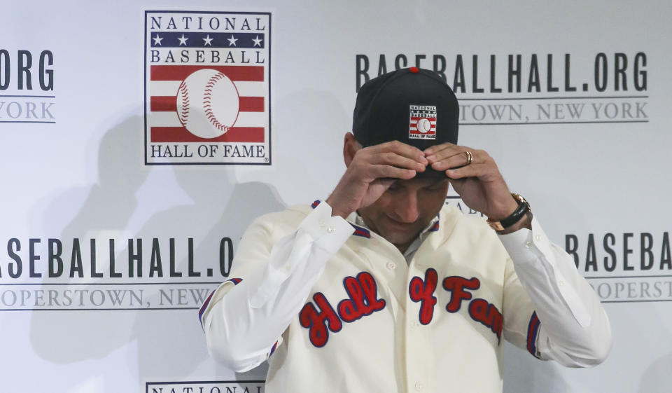 New York Yankees shortstop Derek Jeter fits his cap after receiving his outfit for the Baseball Hall of Fame, Wednesday Jan. 22, 2020, during a news conference in New York. Jeter and Colorado Rockies outfielder Larry Walker will both join the 2020 Hall of Fame class. (AP Photo/Bebeto Matthews)