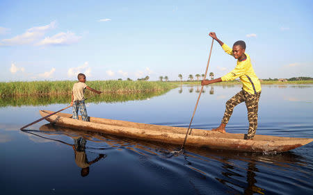 Congolese boys paddle their boat along the Congo River during the vaccination campaign aimed at beating an outbreak of Ebola in the port city of Mbandaka, Democratic Republic of Congo May 22, 2018. REUTERS/Kenny Katombe