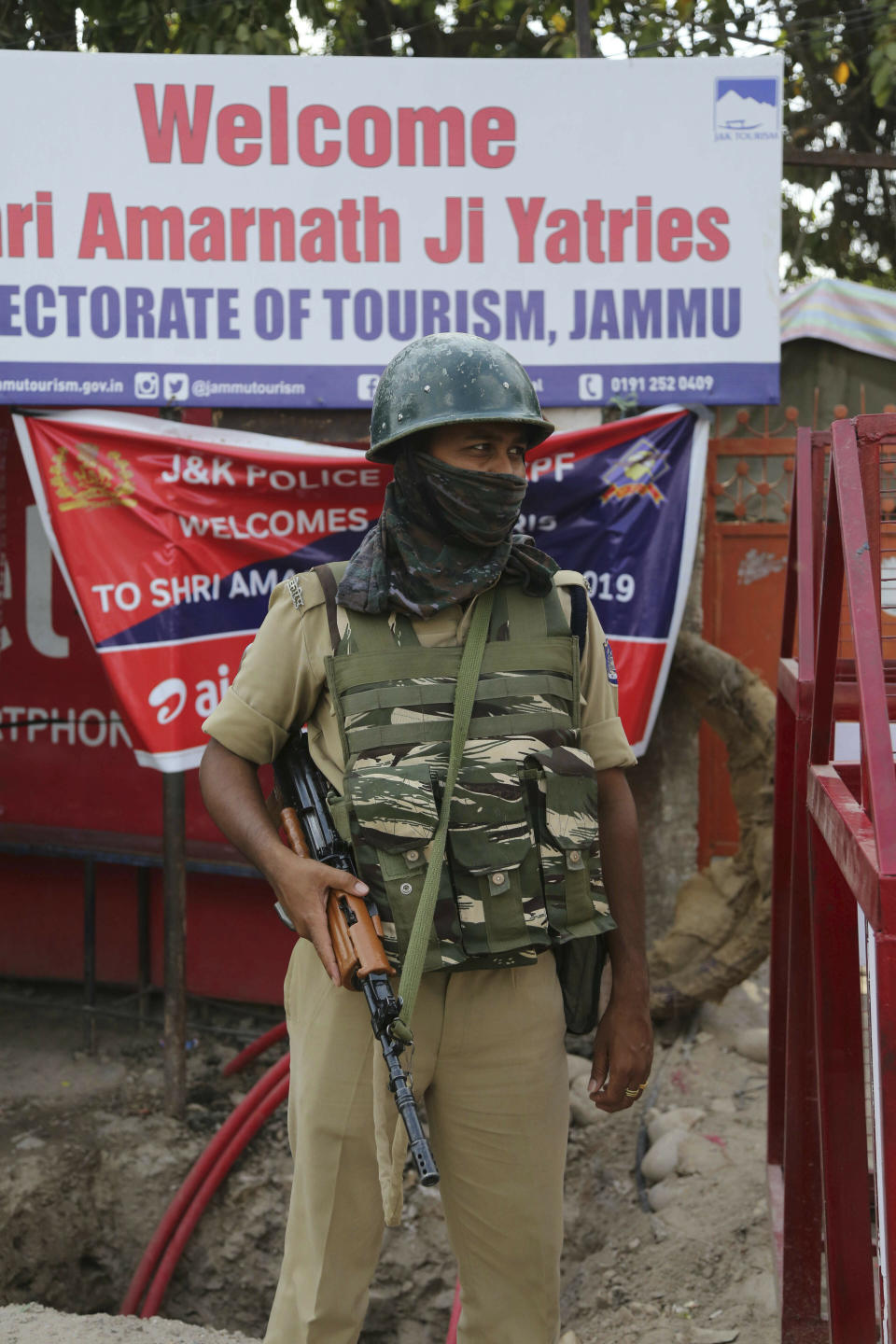 An Indian paramilitary soldier guards outside a base camp for the annual pilgrimage to the Amarnath cave shrine in Jammu, India, Monday, July 1, 2019. Thousands of Hindu pilgrims began the arduous trek to an icy Himalayan cave in disputed Kashmir on Monday, with tens of thousands of Indian government forces guarding roads and mountain passes. (AP Photo/Channi Anand)
