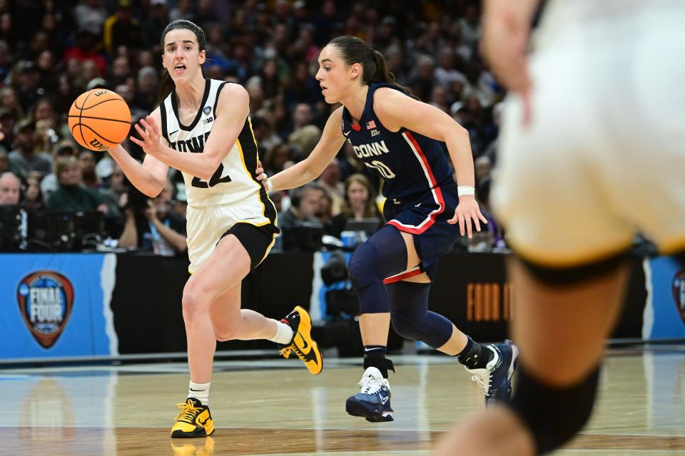 Apr 5, 2024; Cleveland, OH, USA; Iowa Hawkeyes guard Caitlin Clark (22) dribbles the ball past Connecticut Huskies guard Nika Muhl (10) in the semifinals of the Final Four of the womens 2024 NCAA Tournament at Rocket Mortgage FieldHouse. Mandatory Credit: Ken Blaze-USA TODAY Sports