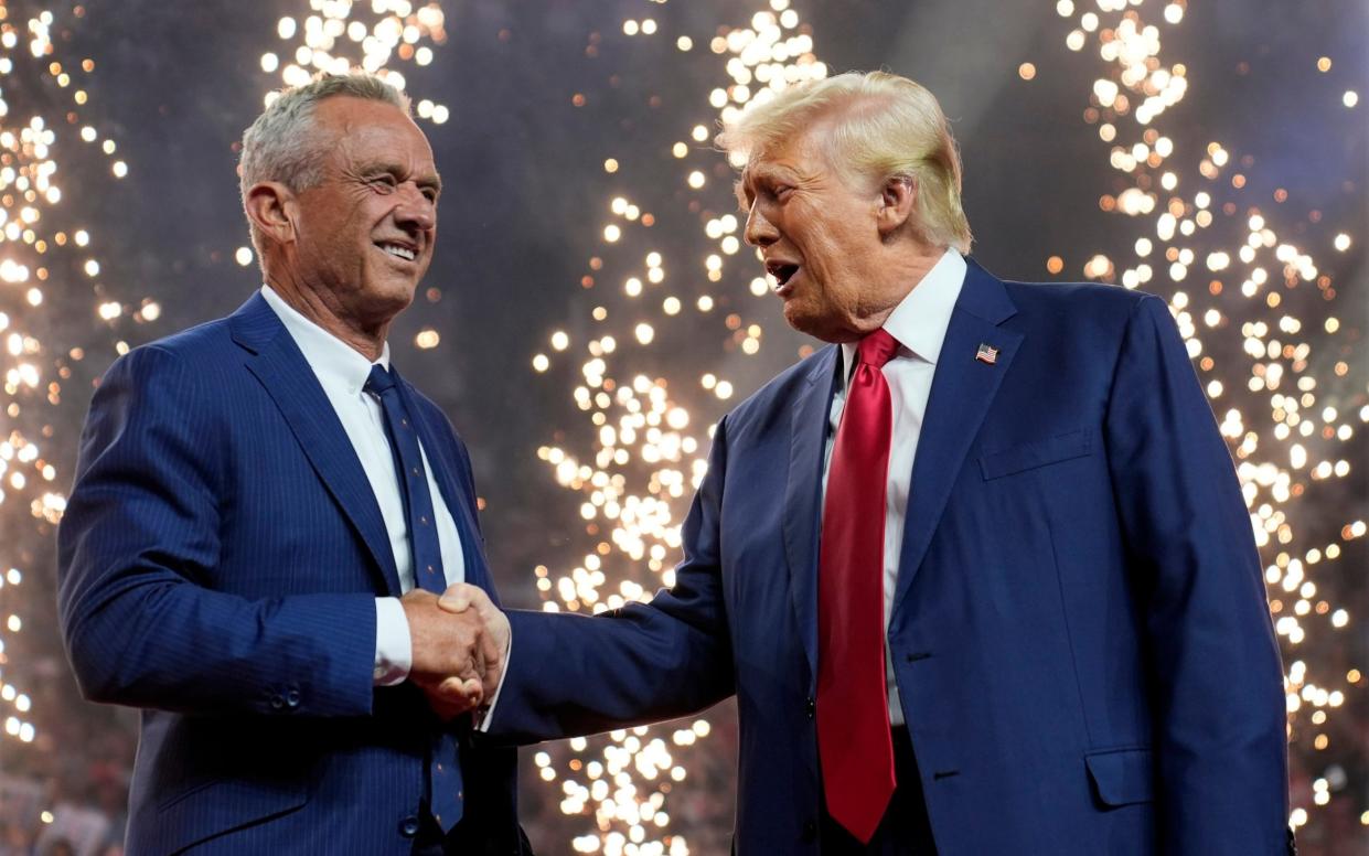 Republican presidential nominee Donald Trump shakes hands with Robert F. Kennedy Jr. at a campaign rally in Glendale, Arizona, on Friday