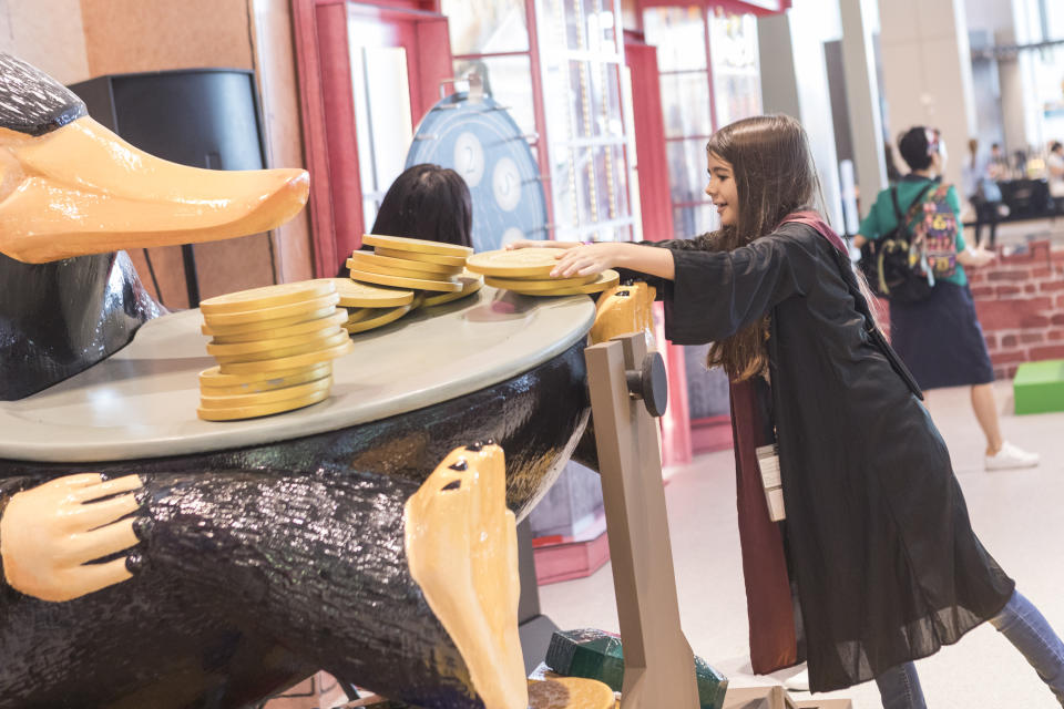 <p>Visitors trying to stack the right number of coins at the Niffler Challenge Game. Picture: Supplied, Changi Airport. </p>