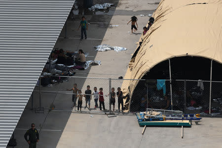 Migrants are seen outside the U.S. Border Patrol McAllen Station in a makeshift encampment in McAllen, Texas, U.S., May 15, 2019. REUTERS/Loren Elliott