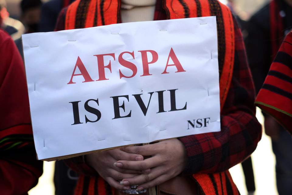 FILE- A Naga holds a placard during a rally protesting the killings of fourteen civilians by Indian army soldiers earlier this month, in Kohima, capital of the northeastern Indian state of Nagaland, Friday, Dec. 17, 2021, file photo. The protestors demanded the revocation of the Armed Forces Special Powers Act, or AFSPA, emergency powers granted to Indian troops, that gives the military sweeping powers to search, seize and even shoot suspects on sight without fear of prosecution. Human rights groups have called the act draconian and pleaded for its repeal for decades. (AP Photo/Yirmiyan Arthur, File)