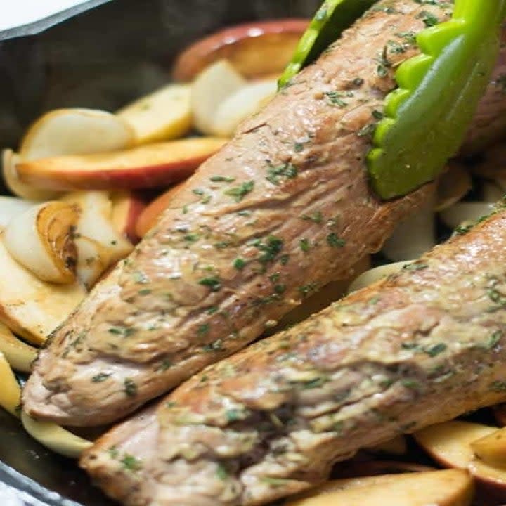 Pork tenderloin cooking in a cast iron skillet