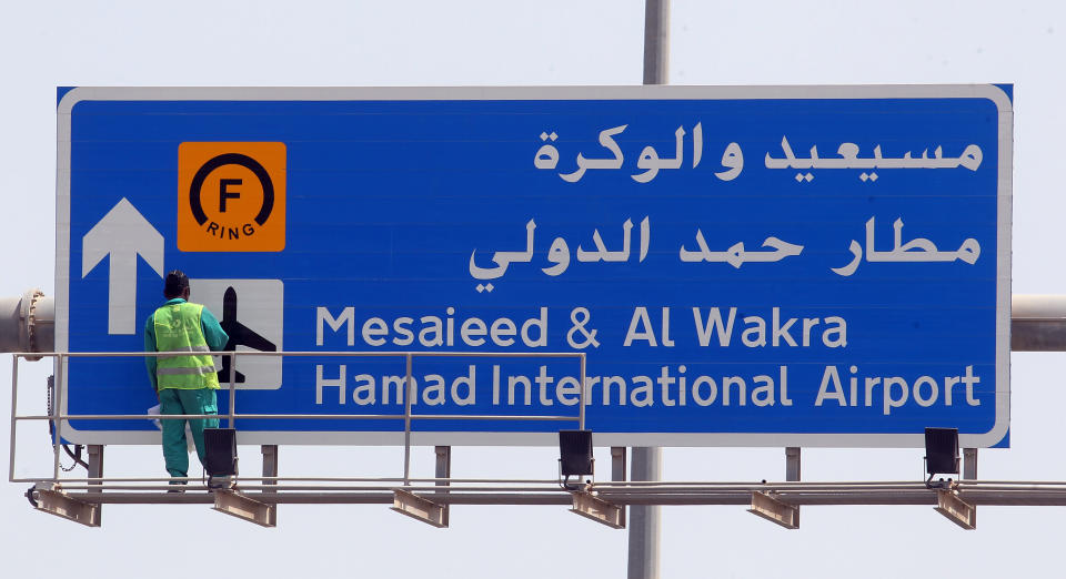 An airport worker puts the final touches on a billboard showing the way to the Hamad International Airport, in Doha, Qatar, Monday, April 1, 2013. The chief overseer of Qatar's new international airport said in a statement Monday, just hours before the scheduled inaugural flight, that the opening of the facility has been delayed because of the need to address new safety requirements. (AP Photo/Osama Faisal)