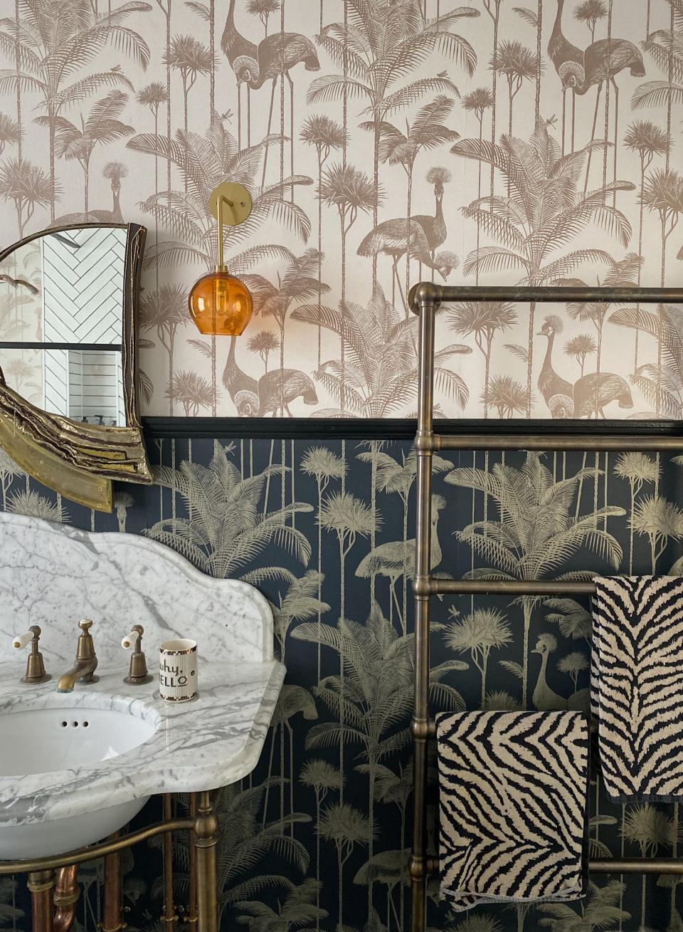 bathroom with wallpaper, marble vanity, towel rail, mirror