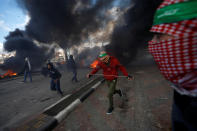 <p>Palestinian protesters run during clashes with Israeli troops at a protest against U.S. President Donald Trump’s decision to recognize Jerusalem as the capital of Israel, near the Jewish settlement of Beit El, near the West Bank city of Ramallah, Dec. 7, 2017. (Photo: Mohamad Torokman/Reuters) </p>