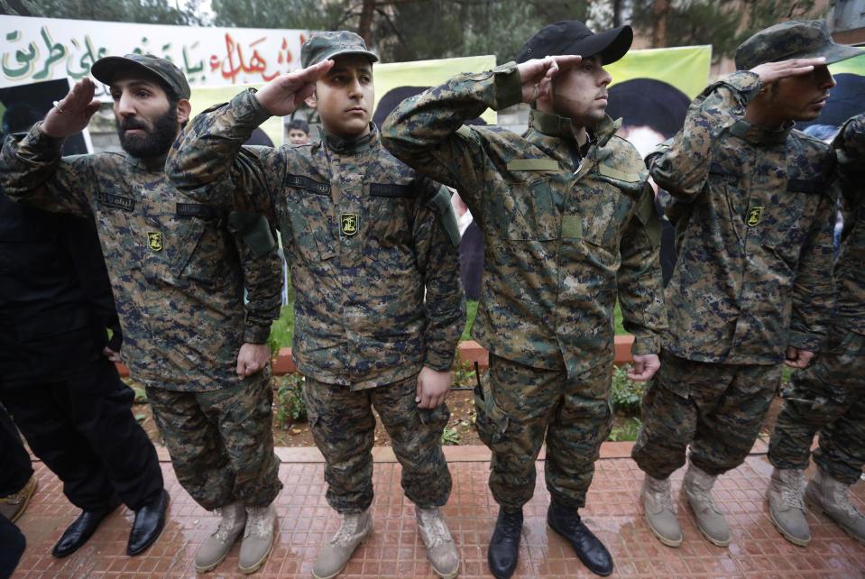 In this December 4, 2013 photo, Hezbollah fighters salute during the funeral procession of Hassan al-Laqis, a senior commander for the Lebanese militant group Hezbollah, who was gunned down, at his hometown in Baalbek city, east Lebanon. The Shiite group has sent hundreds of its fighters into Syria to shore up President Bashar Assad’s overstretched troops, helping them gain ground around the capital, Damascus, and near the Lebanese border. But with its own casualties mounting in a civil war that activists say has killed more than 150,000 people in three years, officials say Hezbollah has turned to a variety of new tactics - including complicated commando operations - to hunt down rebels and opposition commanders. (AP Photo/Hussein Malla)