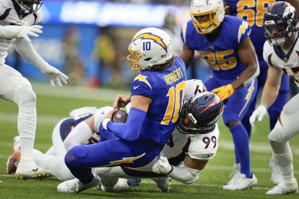 Denver Broncos defensive end Zach Allen (99) sacks Los Angeles Chargers quarterback Justin Herbert (10) during the first half of an NFL football game Sunday, Dec. 10, 2023, in Inglewood, Calif. (AP Photo/Marcio Jose Sanchez)