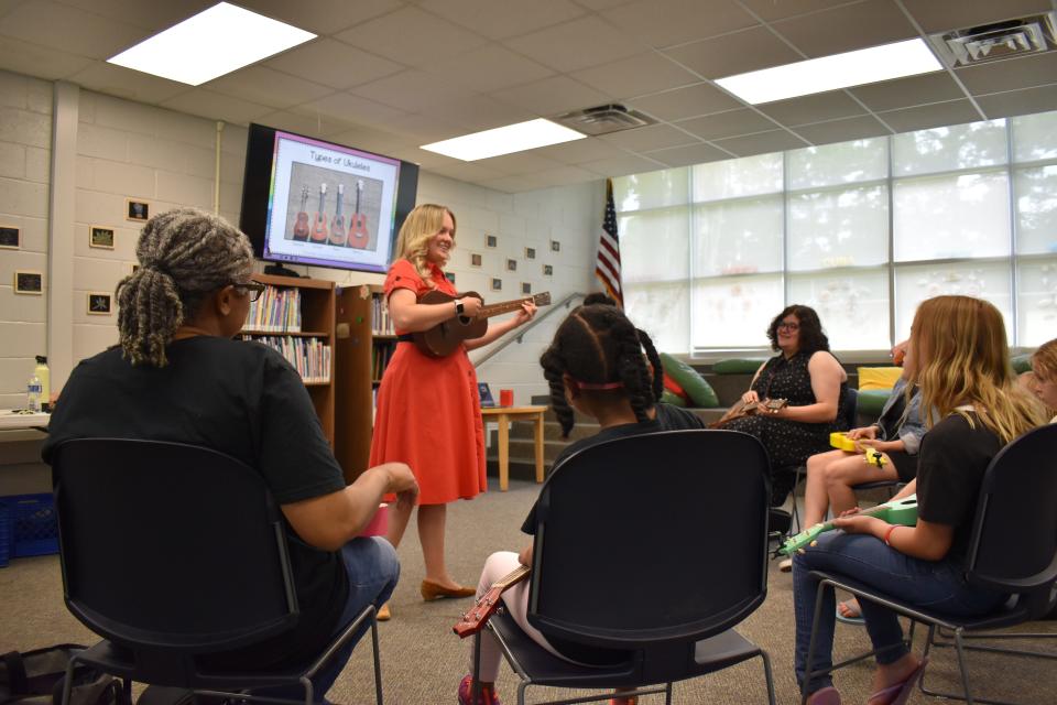 Instructor Mandy Madson introduces new players to the ukulele during a summer workshop at Southwest Chatham Library.