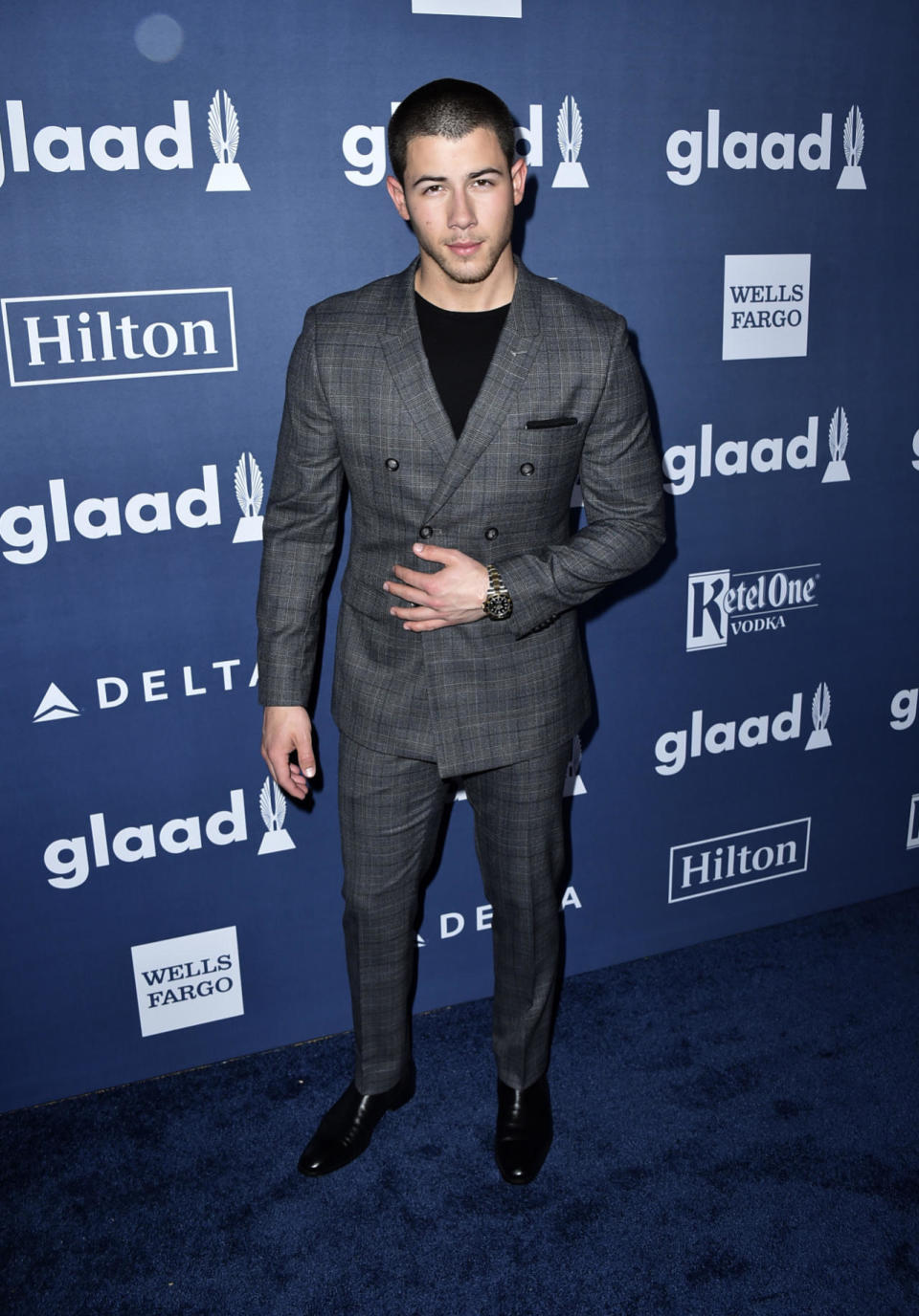 Nick Jonas looking dapper in a gray suit and black T-shirt 