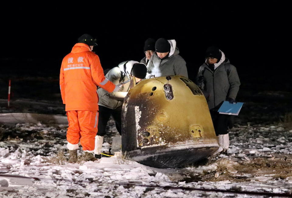 Researchers work next to Chang'e-5 lunar return capsule carrying moon samples, after it landed in northern China's Inner Mongolia Autonomous Region, December 17, 2020. China Daily via REUTERS ATTENTION EDITORS - THIS IMAGE WAS PROVIDED BY A THIRD PARTY. CHINA OUT. - RC2ROK9VIKQY