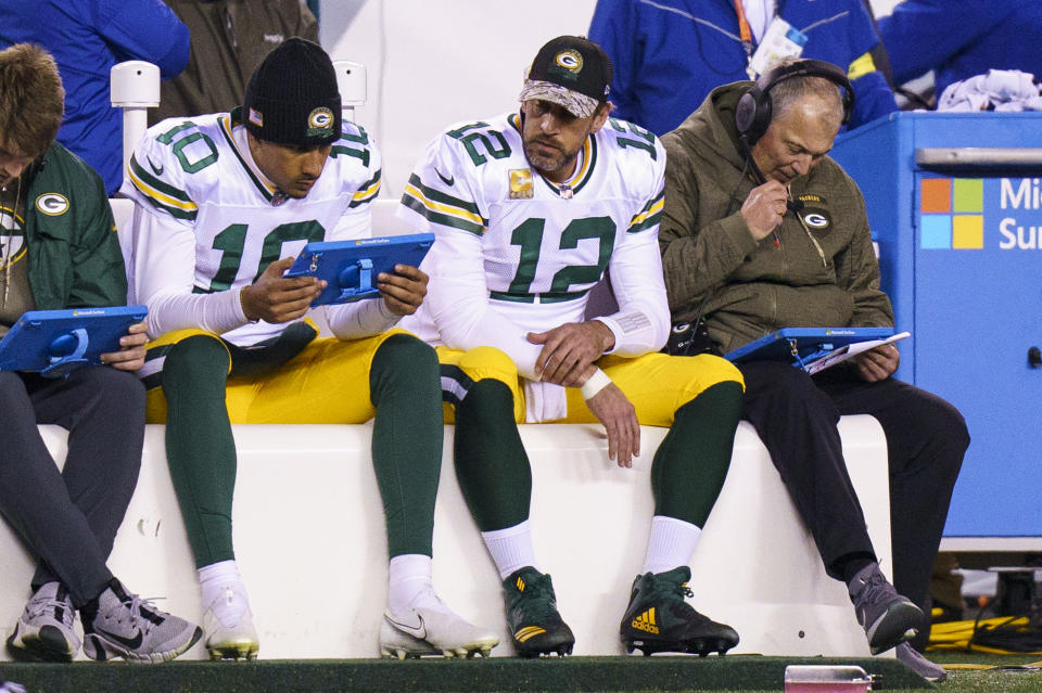 Green Bay Packers quarterback Aaron Rodgers (12)looks on from the bench as quarterback Jordan Love (10) looks over the tablet during the NFL football game against the Philadelphia Eagles, Sunday, Nov. 27, 2022, in Philadelphia. (AP Photo/Chris Szagola)