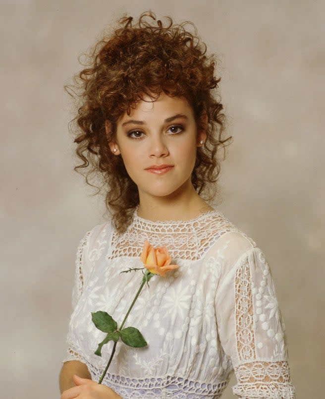 closeup of her holding a single flower