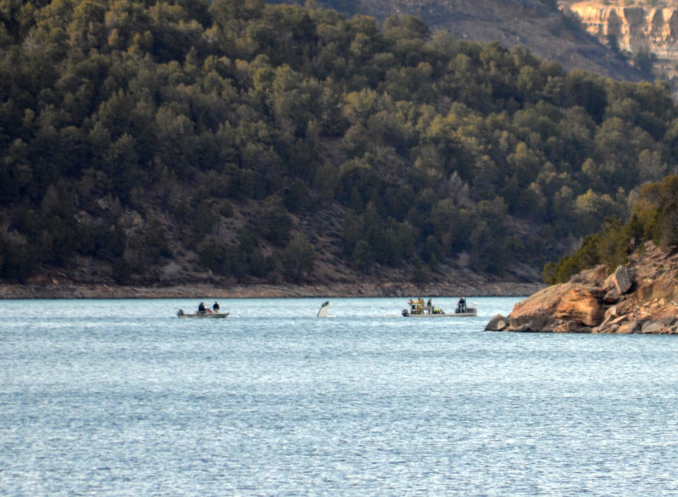 This photo provided by the Ouray County Plaindealer shows rescue personnel towing the tail second of a plane on Saturday, March 22, 2014 after it was recovered from the Ridgeway Reservoir south of Montrose. Colo. The plane believed to be carrying five people crashed into a reservoir in southwestern Colorado and authorities say all are feared dead. Divers are to be used Sunday to search for victims and to recover the rest of the plane. (AP Photo/Ouray County Plaindealer, Bill Tiedje) MANDATORY CREDIT