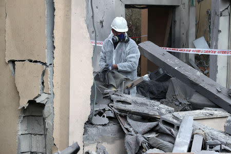 A police sapper inspects a damaged house that was hit by a rocket north of Tel Aviv Israel March 25, 2019. REUTERS/ Ammar Awad