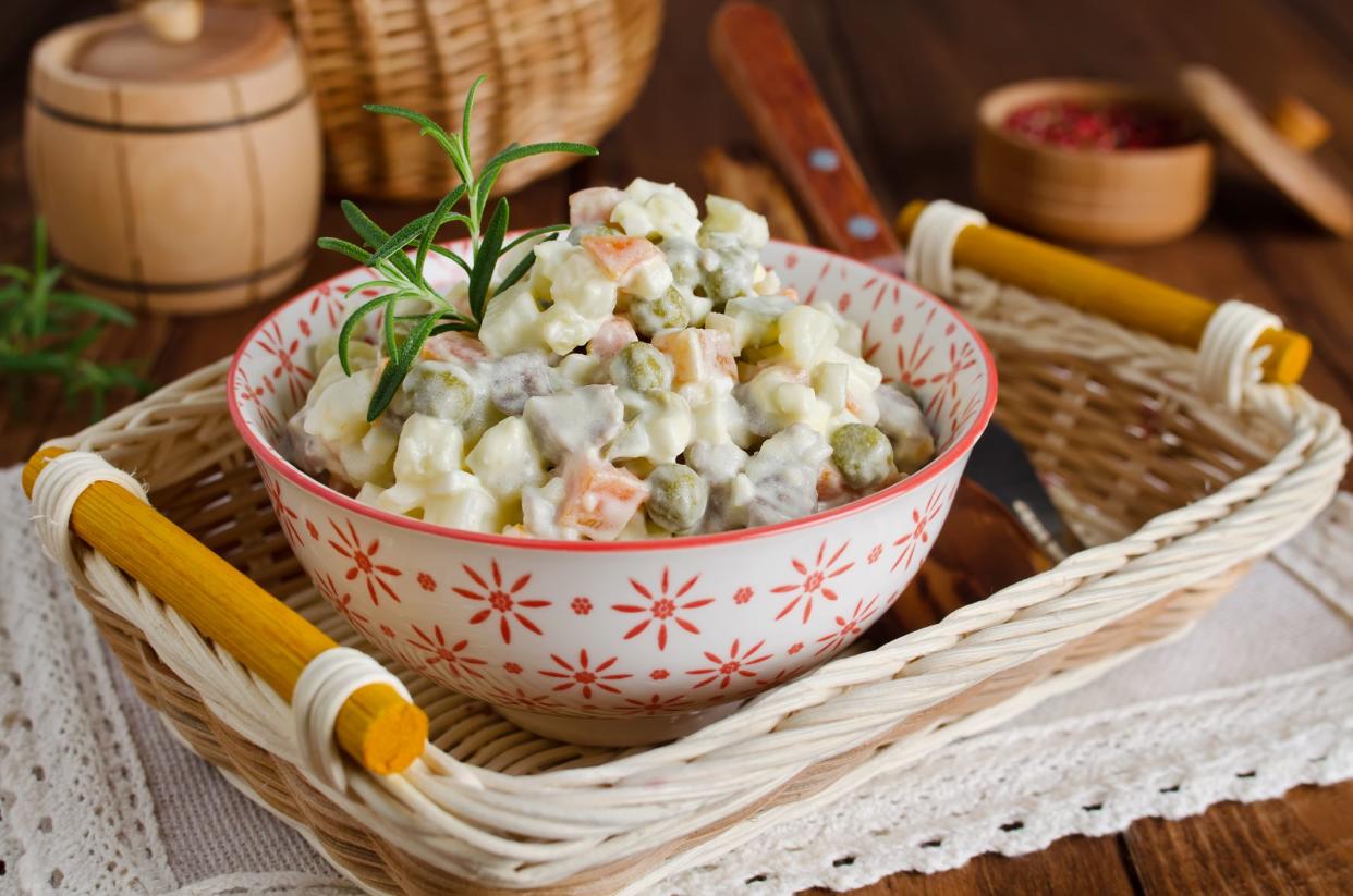 Russian traditional salad Olivier with vegetables and meat. Winter salad