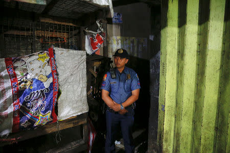 A policeman secures the entrance to the alley where a man was killed during a police drugs buy-bust operation in Manila, Philippines late October 21, 2016. Picture taken October 21, 2016. REUTERS/Damir Sagolj