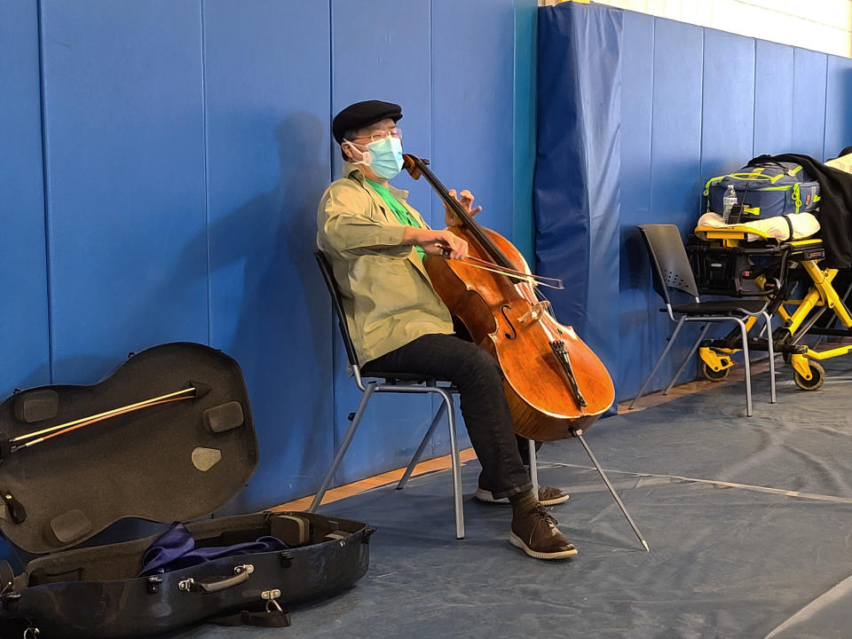 This photo provided by Berkshire Community College shows cellist Yo-Yo Ma performing at Berkshire Community College’s second dose Pfizer vaccination clinic in the Paterson Field House on Saturday, March 13, 2021 in Pittsfield, Mass. Newly vaccinated Massachusetts residents were treated to a mini concert when the famed cellist brought out his instrument after getting his second shot. (Jonah Sykes/Berkshire Community College via AP)